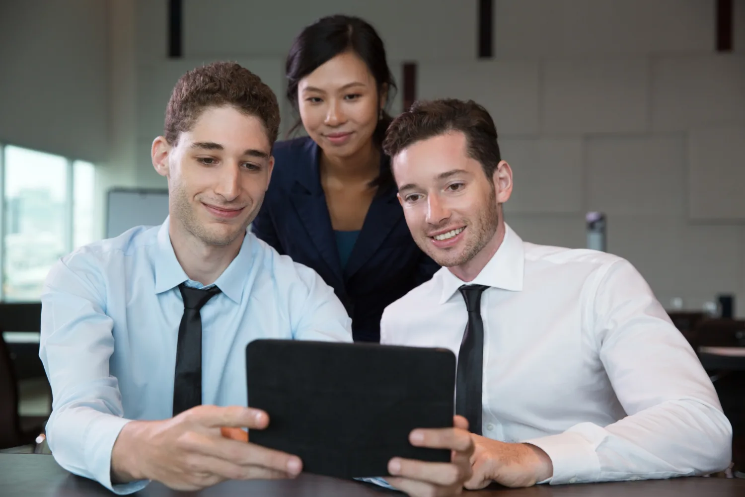 Colleagues reviewing work on a tablet